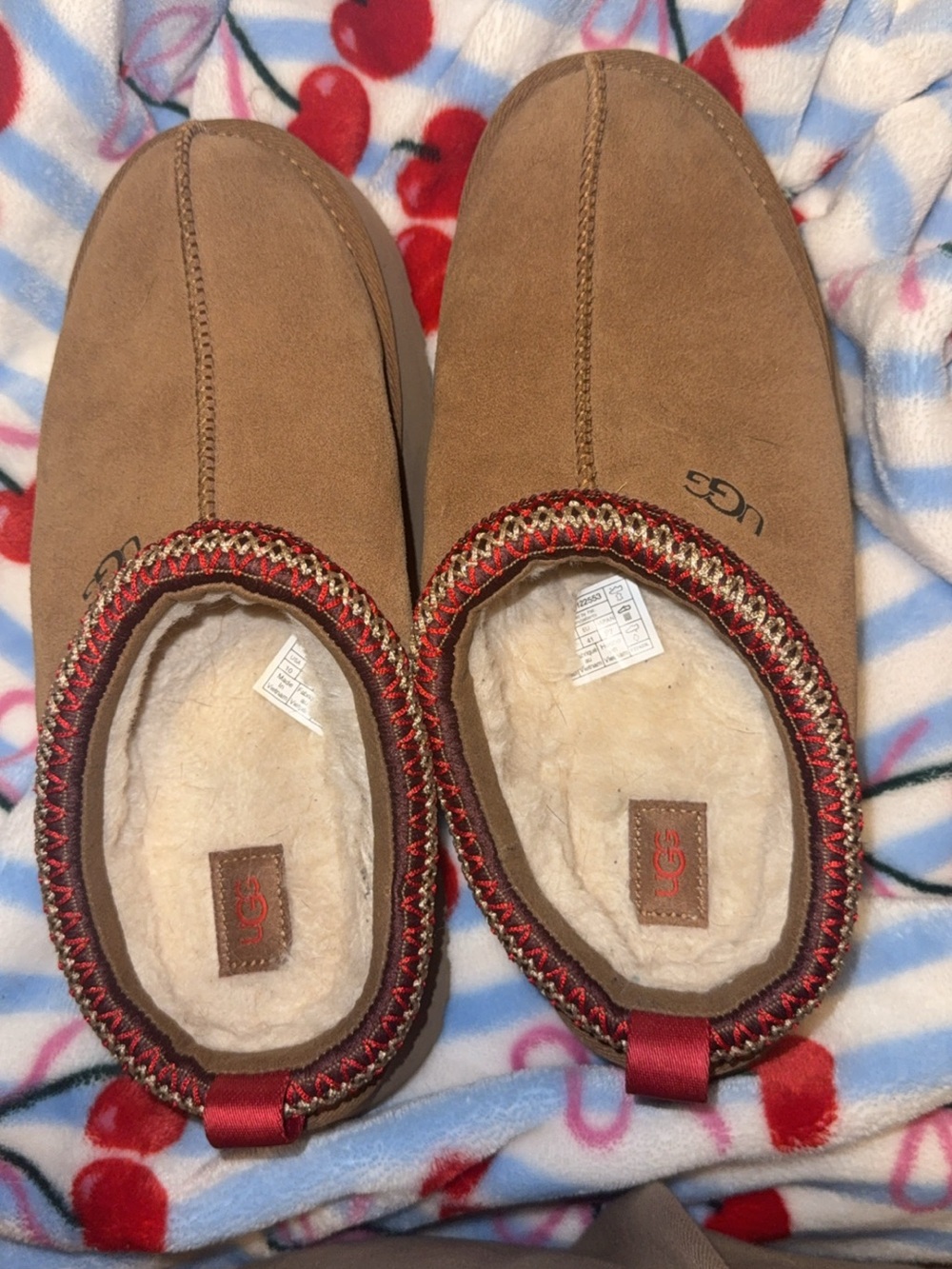 UGG Women's Chestnut/Tan Suede Cozy Slip-On Slippers with Red Trim.